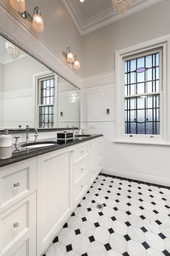 Idee per una stanza da bagno padronale chic di medie dimensioni con ante bianche, piastrelle bianche, pareti beige, pavimento con piastrelle in ceramica, pavimento bianco e top nero