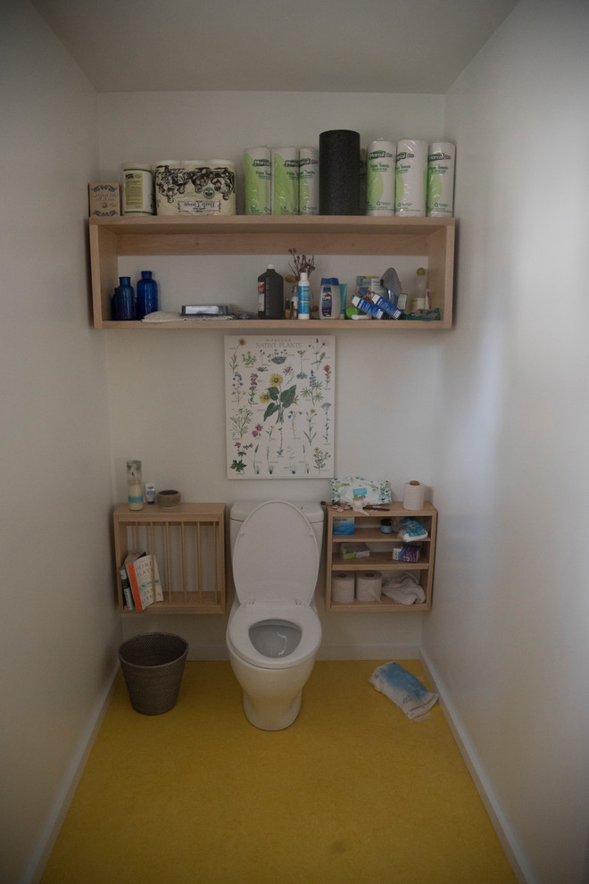 Inspiration för ett nordiskt badrum, med öppna hyllor, skåp i ljust trä, en toalettstol med separat cisternkåpa, vita väggar, gult golv, en dusch i en alkov, ett väggmonterat handfat och med dusch som är öppen