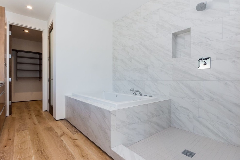 Idéer för att renovera ett mellanstort funkis en-suite badrum, med släta luckor, skåp i mellenmörkt trä, ett platsbyggt badkar, grå kakel, vit kakel, marmorkakel, vita väggar, ljust trägolv, ett undermonterad handfat, bänkskiva i akrylsten, med dusch som är öppen och en dubbeldusch
