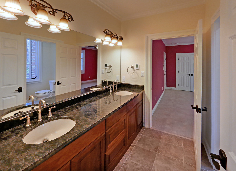 Bathroom - huge traditional kids' multicolored tile and ceramic tile ceramic tile and beige floor bathroom idea in Richmond with raised-panel cabinets, medium tone wood cabinets, beige walls, an undermount sink, granite countertops, black countertops and a two-piece toilet