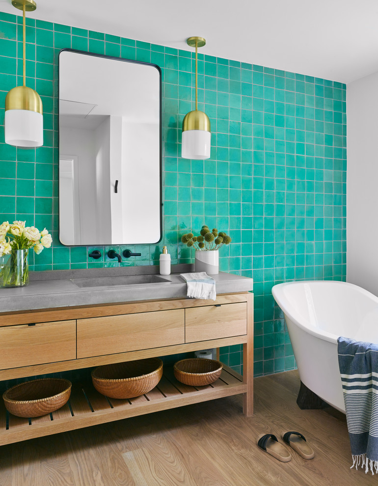 На фото: ванная комната в современном стиле с плоскими фасадами, светлыми деревянными фасадами, отдельно стоящей ванной, синей плиткой, белыми стенами, светлым паркетным полом, монолитной раковиной, столешницей из бетона, бежевым полом, серой столешницей и зеркалом с подсветкой