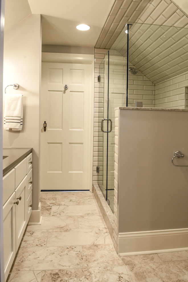 На фото: главная ванная комната в стиле неоклассика (современная классика) с фасадами с утопленной филенкой, белыми фасадами, двойным душем, серой плиткой, плиткой кабанчик, бежевыми стенами, мраморным полом, врезной раковиной, столешницей из гранита, белым полом, душем с распашными дверями и серой столешницей с