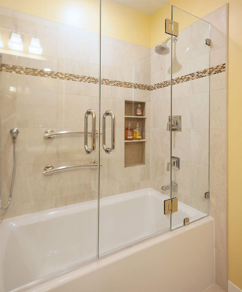 サンフランシスコにある小さなビーチスタイルのおしゃれなマスターバスルーム (アンダーカウンター洗面器、落し込みパネル扉のキャビネット、中間色木目調キャビネット、人工大理石カウンター、アルコーブ型浴槽、シャワー付き浴槽	、分離型トイレ、ベージュのタイル、磁器タイル、黄色い壁、磁器タイルの床) の写真