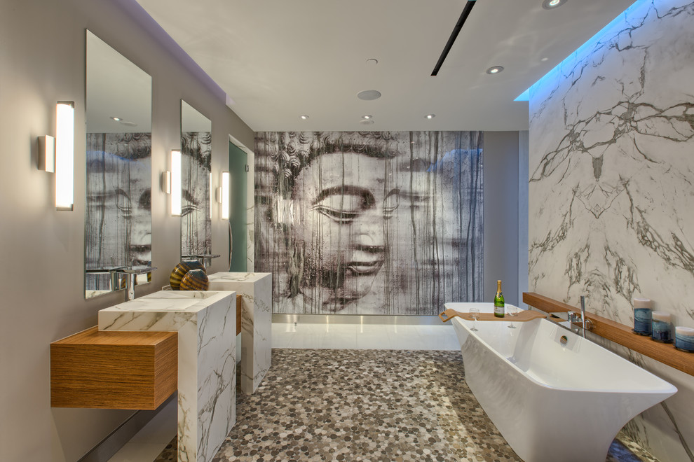 Foto de cuarto de baño contemporáneo con lavabo de seno grande, bañera exenta y suelo de baldosas tipo guijarro