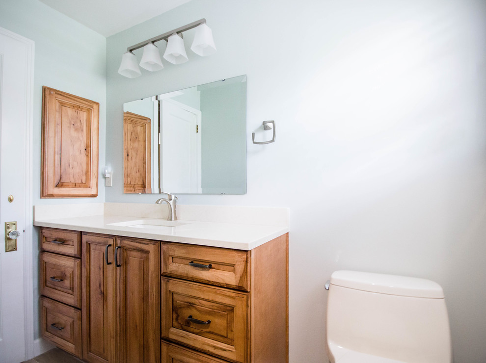 Immagine di una piccola stanza da bagno tradizionale con ante con bugna sagomata, ante in legno scuro, WC monopezzo, lavabo sottopiano e top in quarzo composito
