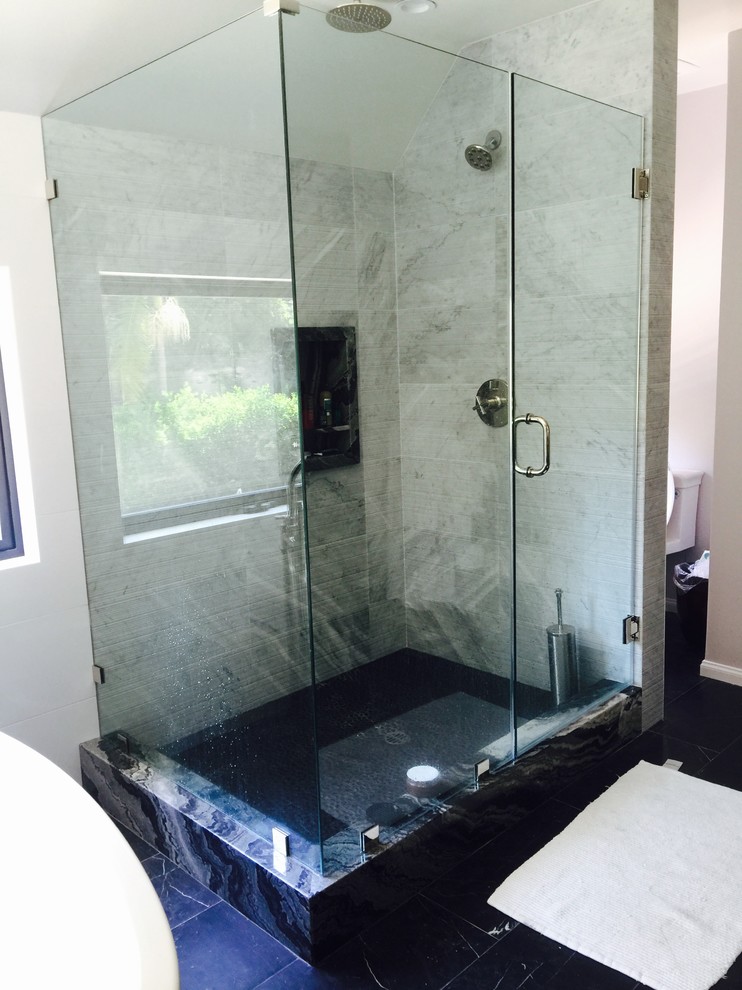 Cette image montre une salle de bain principale design de taille moyenne avec un placard à porte affleurante, des portes de placard grises, un mur gris, un sol en marbre, un lavabo encastré et un plan de toilette en onyx.