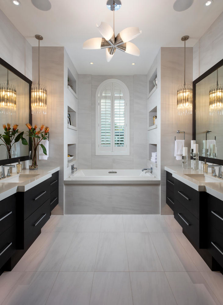 Immagine di una stanza da bagno padronale stile marino con ante lisce, ante nere, vasca da incasso, piastrelle grigie, pareti grigie, lavabo sottopiano, pavimento grigio e top grigio
