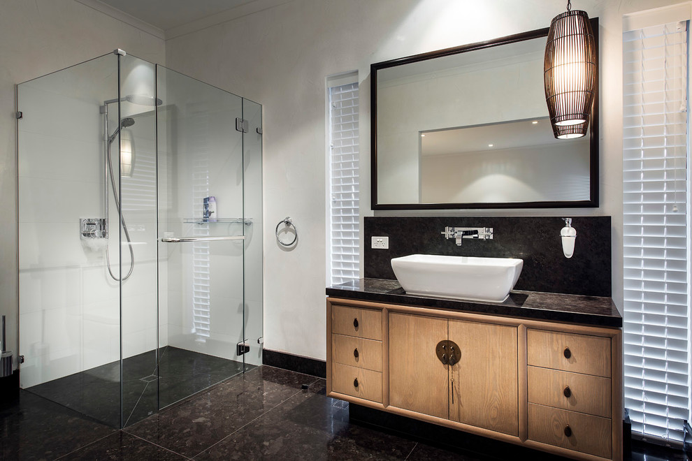 Imagen de cuarto de baño rectangular contemporáneo con lavabo sobreencimera, armarios con paneles lisos, puertas de armario de madera oscura, ducha esquinera y paredes blancas