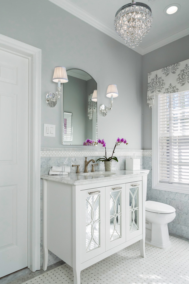 Inredning av ett klassiskt mellanstort en-suite badrum, med vita skåp, vit kakel, målat trägolv, vitt golv, en toalettstol med separat cisternkåpa, ett undermonterad handfat och en dubbeldusch