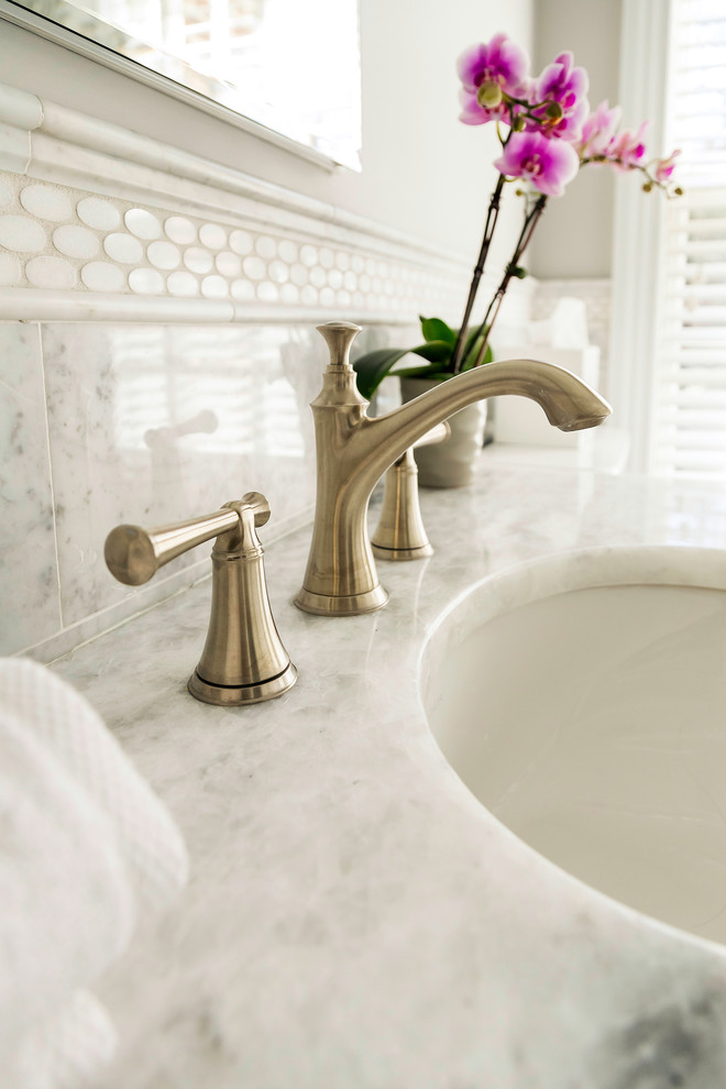 ニューヨークにある中くらいなトランジショナルスタイルのおしゃれなマスターバスルーム (白いキャビネット、白いタイル、塗装フローリング、白い床、分離型トイレ、アンダーカウンター洗面器、ダブルシャワー) の写真