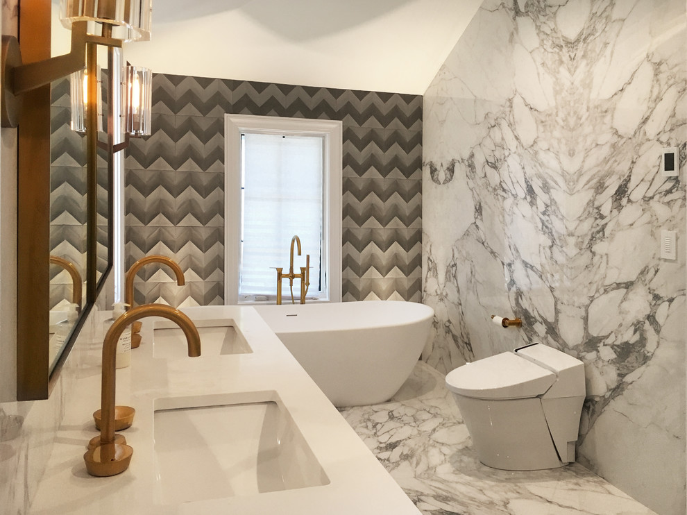 This is an example of a classic bathroom in New York with dark wood cabinets, a freestanding bath, grey tiles, marble tiles, white walls, marble flooring, engineered stone worktops, white floors and white worktops.