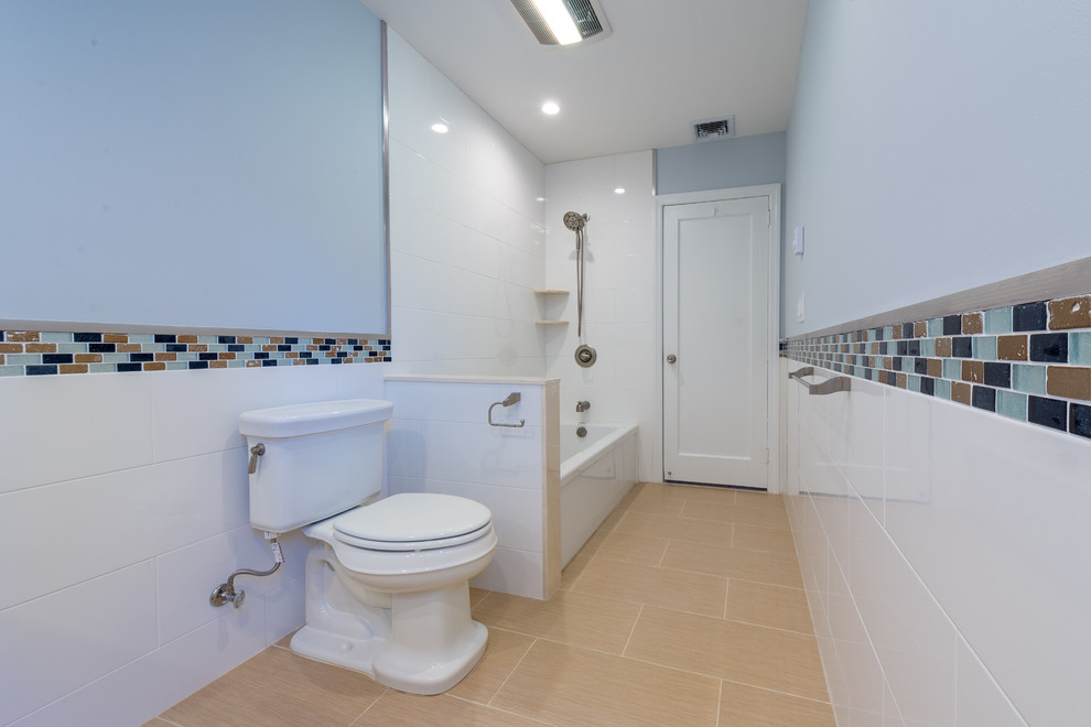 Bathroom - mid-sized contemporary kids' multicolored tile and porcelain tile porcelain tile bathroom idea in New York with an undermount sink, furniture-like cabinets, white cabinets, solid surface countertops, a two-piece toilet and multicolored walls
