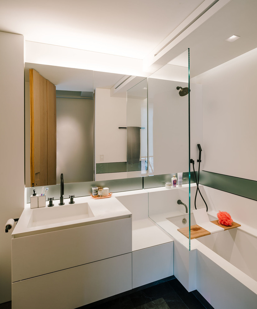 Large minimalist master bathroom photo in New York with flat-panel cabinets, white cabinets, an undermount tub, white walls, an integrated sink and quartz countertops