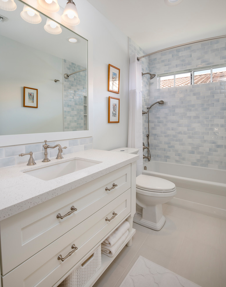 Transitional blue tile and white tile beige floor bathroom photo with beaded inset cabinets, white cabinets, a two-piece toilet, white walls and an undermount sink