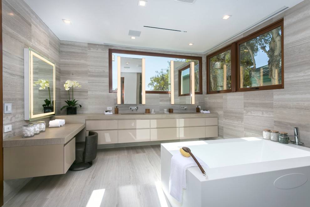 Esempio di una stanza da bagno padronale minimalista con ante lisce, ante beige, vasca da incasso, piastrelle grigie, piastrelle di pietra calcarea, pareti grigie, lavabo sottopiano e pavimento grigio