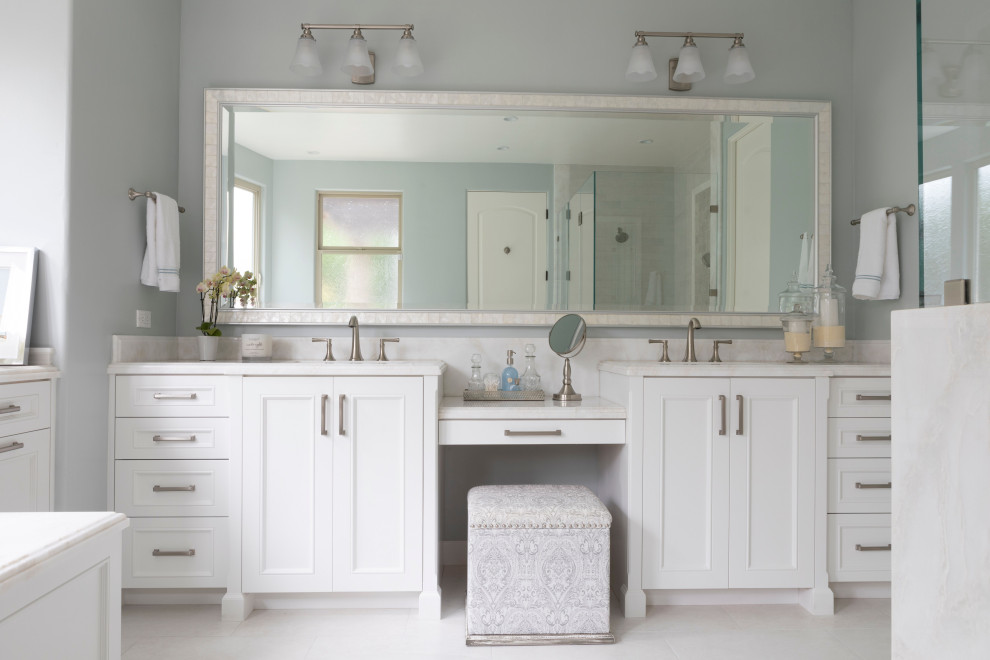 Réalisation d'une grande salle de bain principale tradition avec un placard avec porte à panneau encastré, des portes de placard blanches, un mur bleu, un sol en marbre, un lavabo encastré, un plan de toilette en marbre, un sol blanc et un plan de toilette blanc.