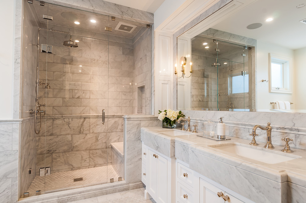 Foto på ett stort lantligt vit en-suite badrum, med luckor med infälld panel, vita skåp, en dusch i en alkov, grå kakel, marmorkakel, vita väggar, marmorgolv, ett undermonterad handfat, marmorbänkskiva, vitt golv och dusch med gångjärnsdörr