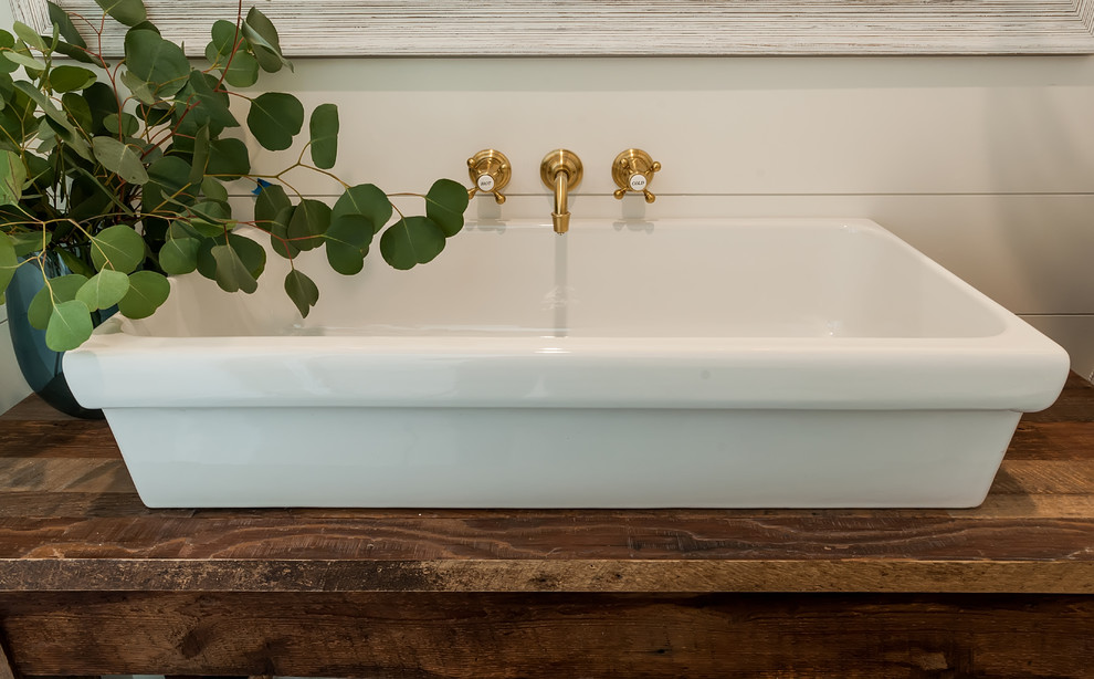 Réalisation d'une salle d'eau champêtre en bois brun de taille moyenne avec un placard sans porte, un mur blanc, un sol en calcaire, une vasque, un plan de toilette en bois, un sol beige et un plan de toilette marron.
