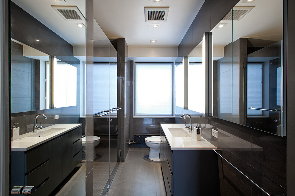 Idee per una stretta e lunga stanza da bagno design con ante lisce, ante nere, doccia a filo pavimento e piastrelle nere