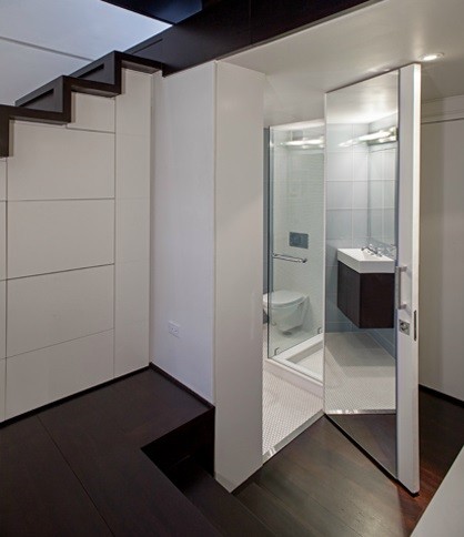 Kleines Modernes Badezimmer En Suite mit Wandwaschbecken, Eckdusche, Glasfliesen, flächenbündigen Schrankfronten, weißen Schränken und dunklem Holzboden in New York