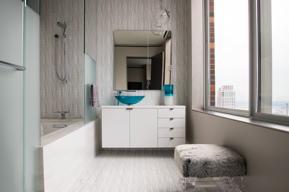 This is an example of a contemporary bathroom in New York with a vessel sink, flat-panel cabinets, white cabinets and an alcove bath.