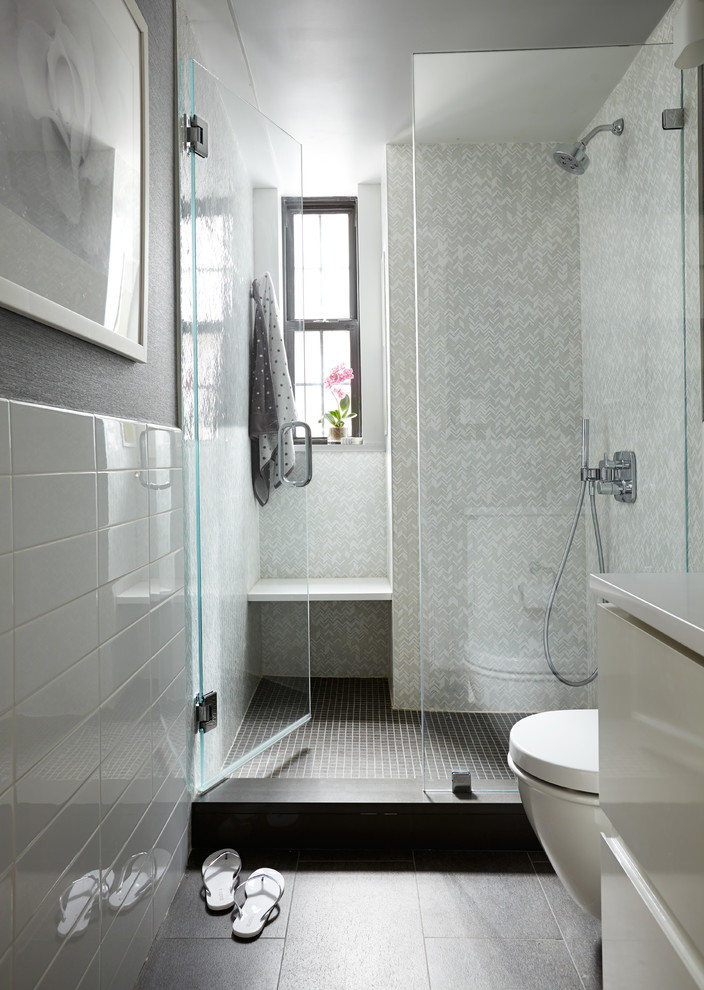 Diseño de cuarto de baño contemporáneo con armarios con paneles lisos, puertas de armario blancas, ducha empotrada, baldosas y/o azulejos grises y paredes grises