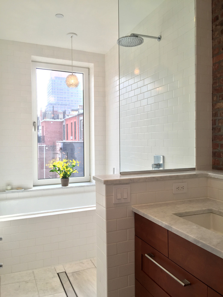 Example of a danish master white tile and subway tile marble floor bathroom design in New York with flat-panel cabinets, medium tone wood cabinets, a one-piece toilet, white walls, marble countertops and an undermount sink
