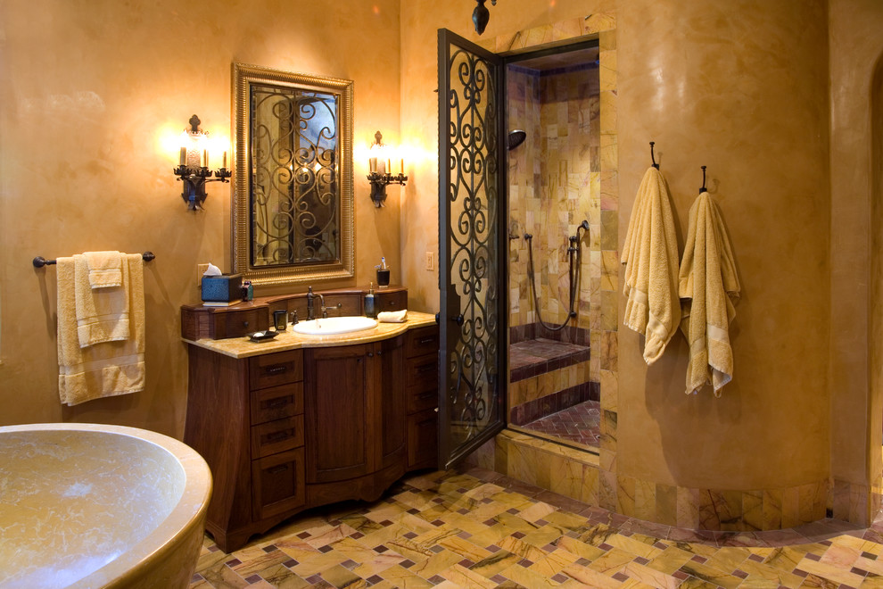 На фото: ванная комната в средиземноморском стиле с накладной раковиной, отдельно стоящей ванной, душем в нише и бежевой плиткой с