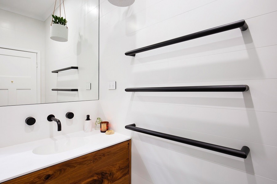 Bild på ett mellanstort funkis vit vitt badrum med dusch, med möbel-liknande, skåp i mörkt trä, våtrum, en vägghängd toalettstol, svart och vit kakel, stenkakel, vita väggar, terrazzogolv, ett integrerad handfat, bänkskiva i kvarts, flerfärgat golv och dusch med gångjärnsdörr