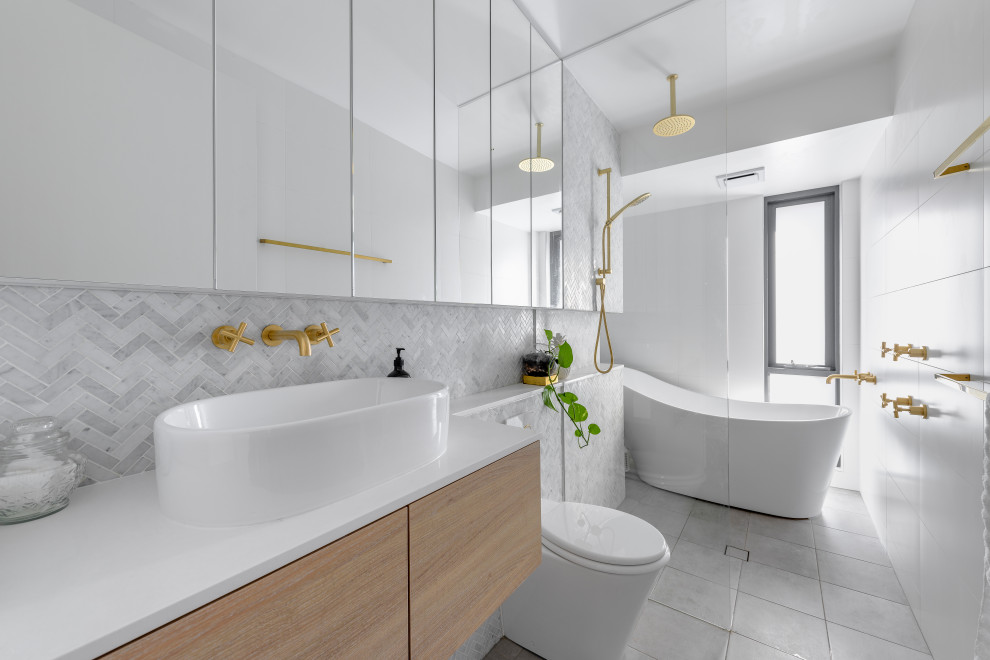 Inspiration för mellanstora moderna vitt en-suite badrum, med möbel-liknande, skåp i ljust trä, ett fristående badkar, en öppen dusch, en vägghängd toalettstol, vit kakel, vita väggar, bänkskiva i akrylsten, grått golv och med dusch som är öppen