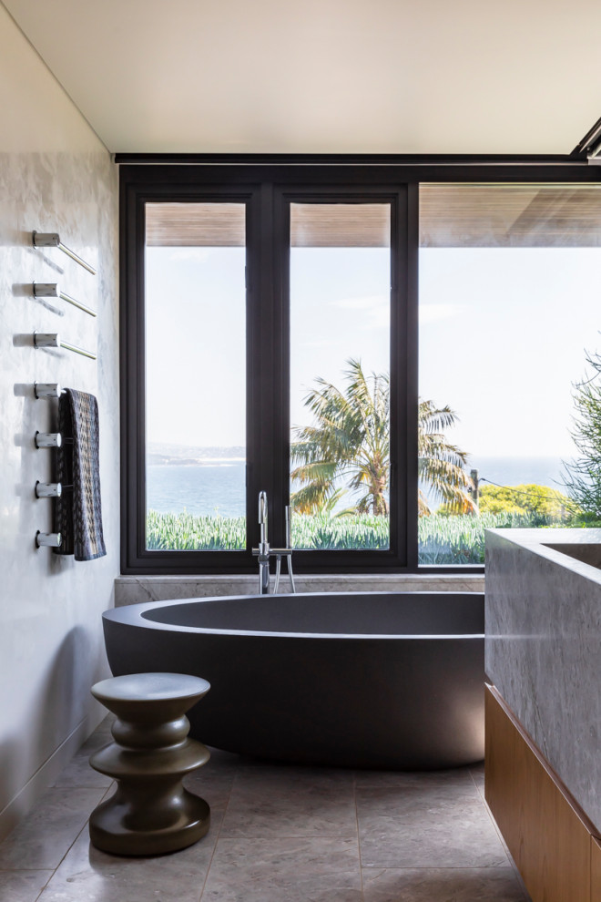 Modern inredning av ett stort en-suite badrum, med ett fristående badkar, grå väggar, klinkergolv i porslin och grått golv