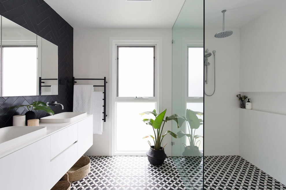 Стильный дизайн: ванная комната в современном стиле с плоскими фасадами, белыми фасадами, душем без бортиков, черной плиткой, белыми стенами, душевой кабиной, накладной раковиной, черным полом и открытым душем - последний тренд