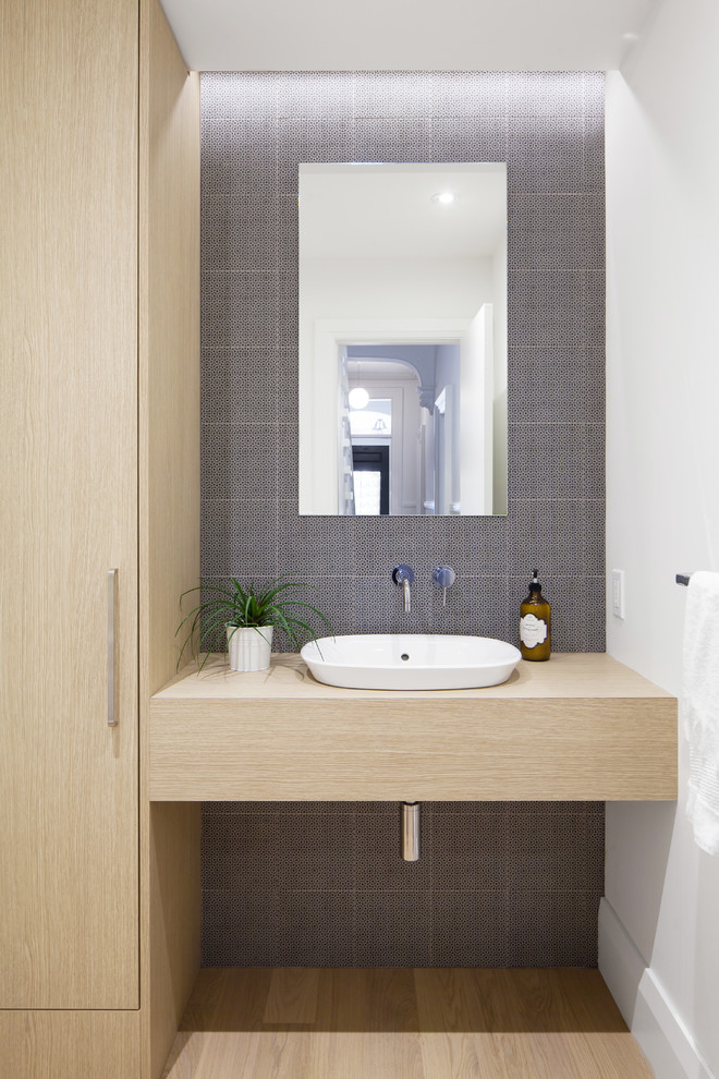 Exempel på ett modernt badrum, med släta luckor, vita väggar, ett undermonterad handfat, bänkskiva i kvarts, skåp i ljust trä, blå kakel och mellanmörkt trägolv