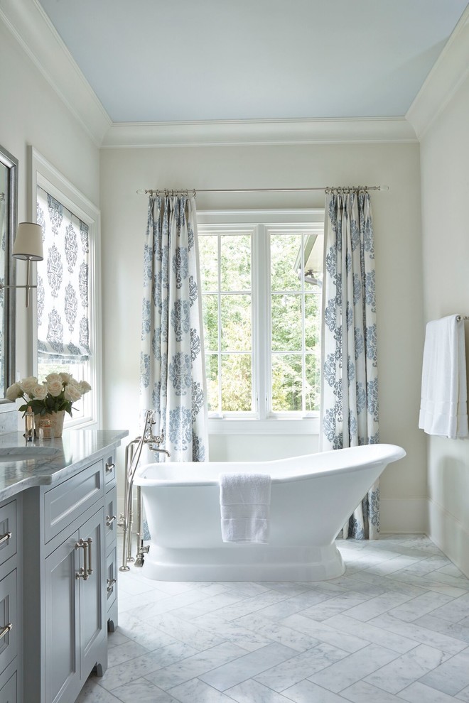 Klassisk inredning av ett stort en-suite badrum, med skåp i shakerstil, grå skåp, ett fristående badkar, en öppen dusch, en toalettstol med hel cisternkåpa, grå kakel, stenkakel, vita väggar, marmorgolv, ett undermonterad handfat och marmorbänkskiva