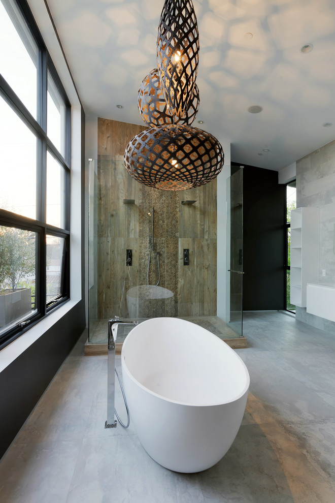 Esempio di una grande stanza da bagno padronale minimal con pareti grigie, pavimento in cemento, ante lisce, ante bianche, vasca freestanding, doccia ad angolo e lavabo integrato