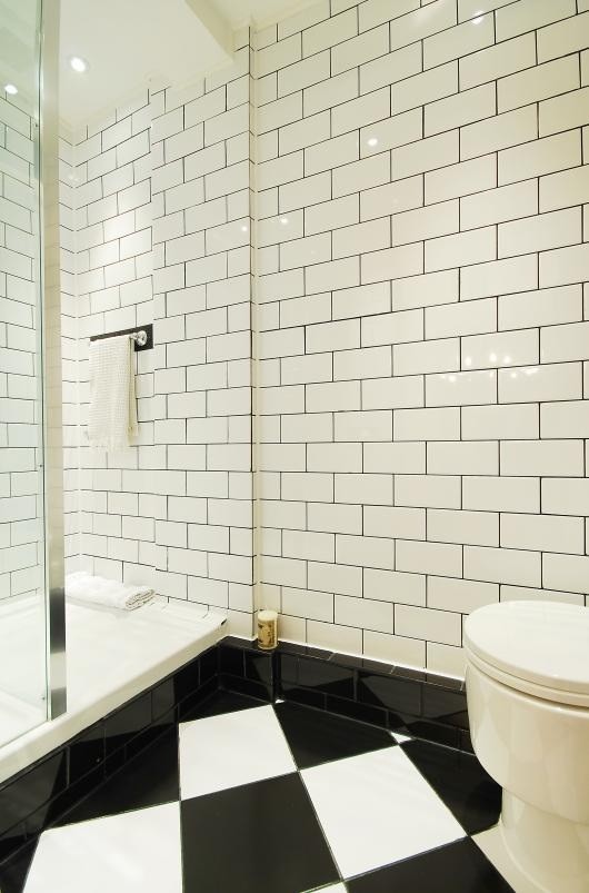 Foto di una piccola stanza da bagno moderna con lavabo a consolle, ante lisce, ante nere, top piastrellato, doccia aperta, WC monopezzo, piastrelle nere, piastrelle in ceramica, pareti bianche e pavimento con piastrelle in ceramica