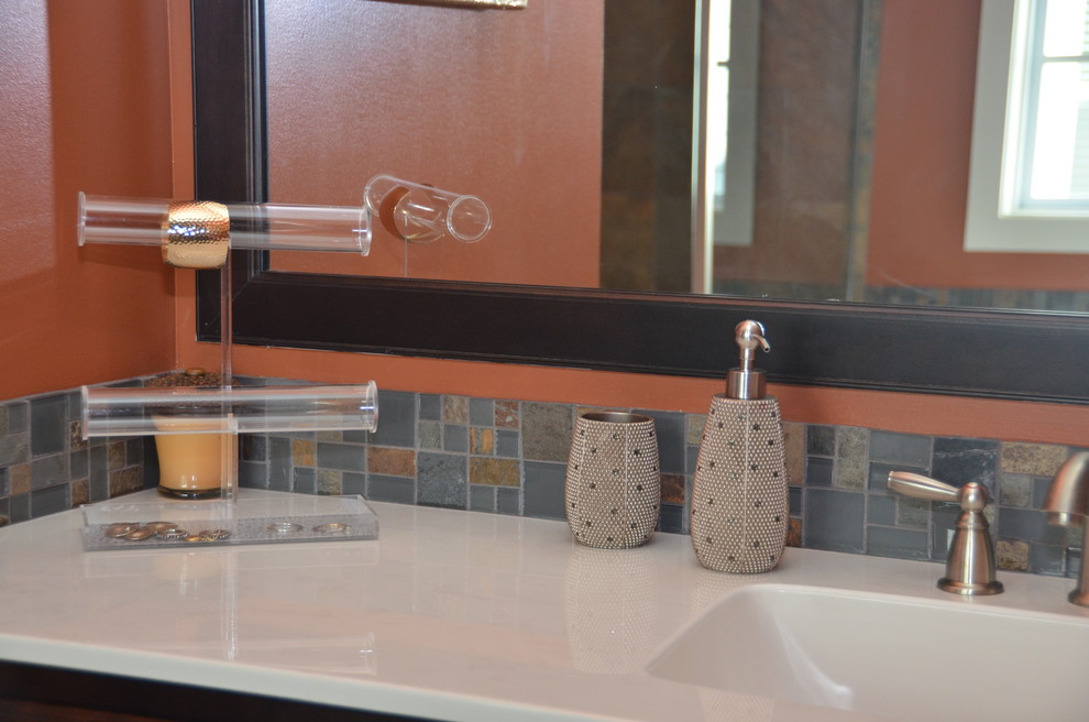 На фото: главная ванная комната среднего размера в стиле фьюжн с фасадами с утопленной филенкой, темными деревянными фасадами, накладной ванной, душем в нише, коричневой плиткой, серой плиткой, плиткой из сланца, оранжевыми стенами, полом из сланца, монолитной раковиной, столешницей из искусственного кварца, коричневым полом и душем с распашными дверями