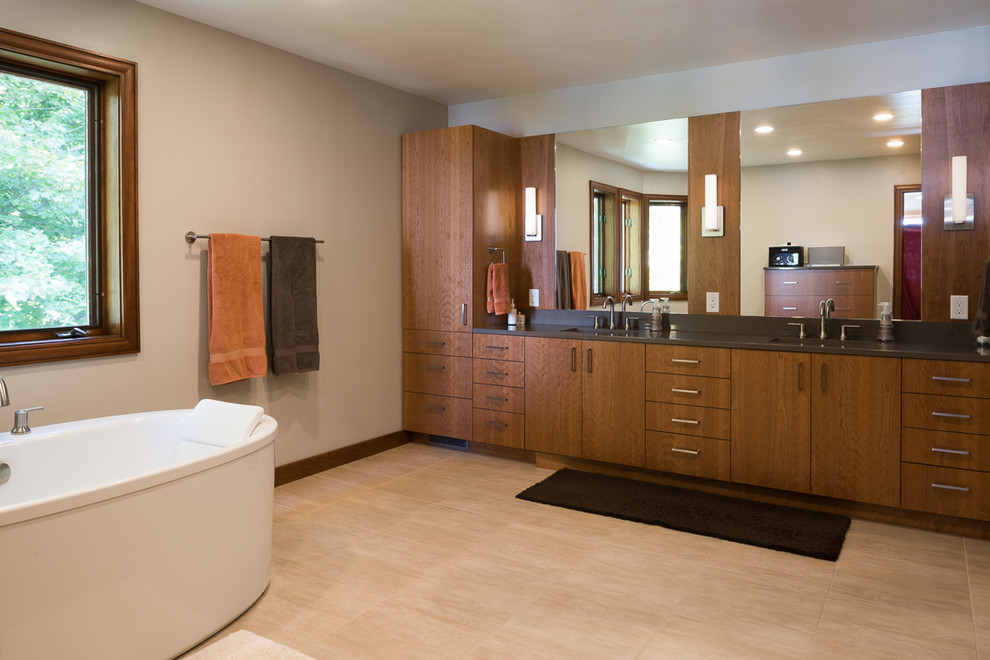 Пример оригинального дизайна: главная ванная комната в современном стиле с плоскими фасадами, темными деревянными фасадами, отдельно стоящей ванной, бежевыми стенами и тумбой под две раковины