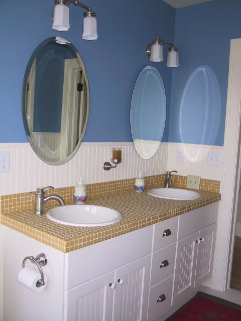 Пример оригинального дизайна: ванная комната среднего размера в классическом стиле с белыми фасадами, желтой плиткой, синими стенами, столешницей из плитки, фасадами с утопленной филенкой, керамической плиткой, полом из мозаичной плитки, накладной раковиной, панелями на стенах, желтым полом, бежевой столешницей и тумбой под две раковины