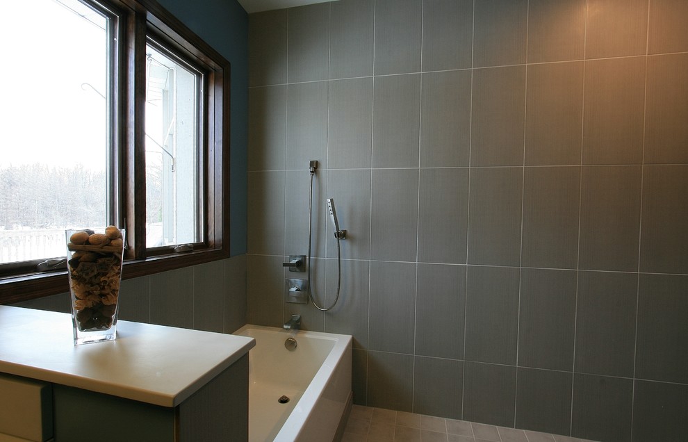 Diseño de cuarto de baño principal minimalista de tamaño medio con bañera esquinera, combinación de ducha y bañera, sanitario de una pieza y baldosas y/o azulejos multicolor