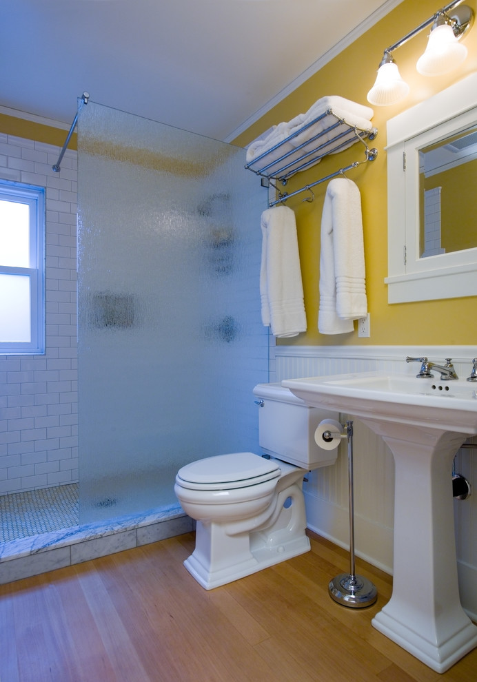 Идея дизайна: главная ванная комната среднего размера в классическом стиле с открытым душем, раздельным унитазом, белой плиткой, плиткой кабанчик, желтыми стенами, светлым паркетным полом и раковиной с пьедесталом