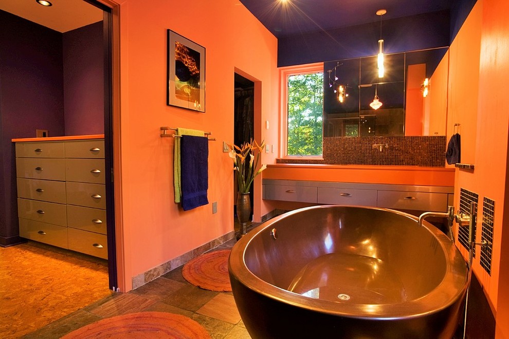 Freestanding bathtub - large eclectic master freestanding bathtub idea in New York with flat-panel cabinets and orange walls