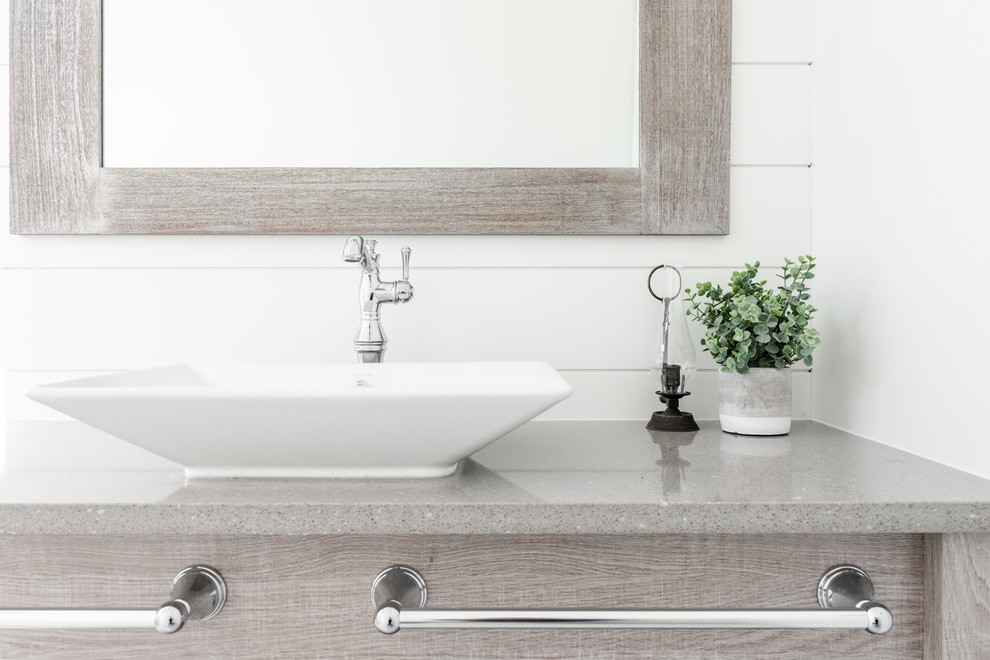 Aménagement d'une grande salle de bain campagne en bois clair avec un sol en carrelage de porcelaine, une vasque, un plan de toilette en quartz modifié, un sol blanc et un plan de toilette gris.