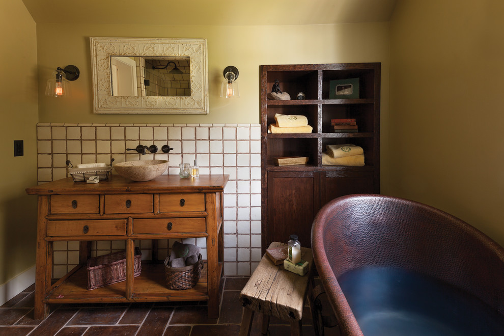 Exempel på ett lantligt badrum, med ett fristående handfat, skåp i mellenmörkt trä, träbänkskiva, ett fristående badkar, beige kakel och öppna hyllor