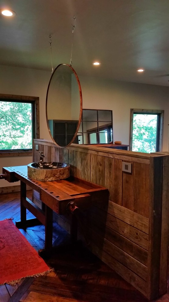 Imagen de cuarto de baño principal rural con lavabo sobreencimera, armarios abiertos, encimera de madera y suelo de madera en tonos medios