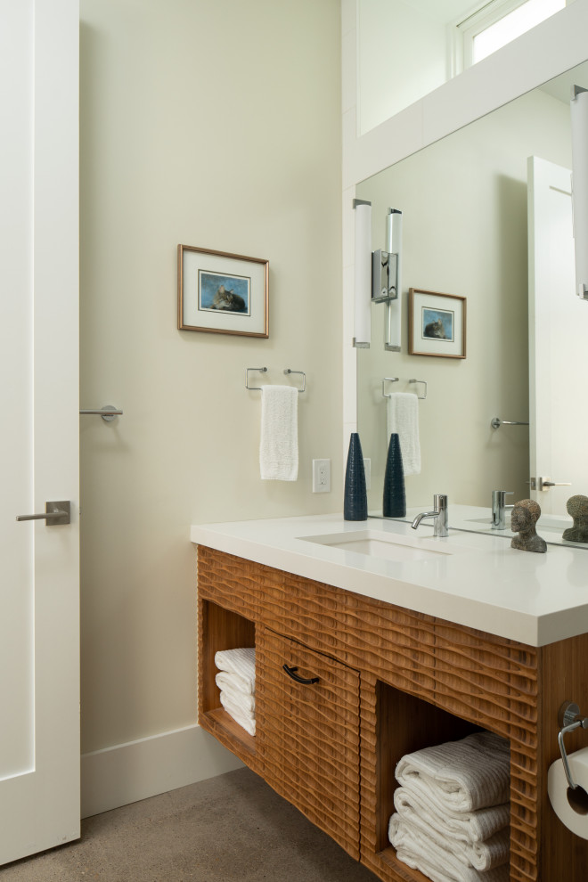 Bathroom - southwestern gray floor bathroom idea in Denver with open cabinets, medium tone wood cabinets, beige walls, an undermount sink and white countertops