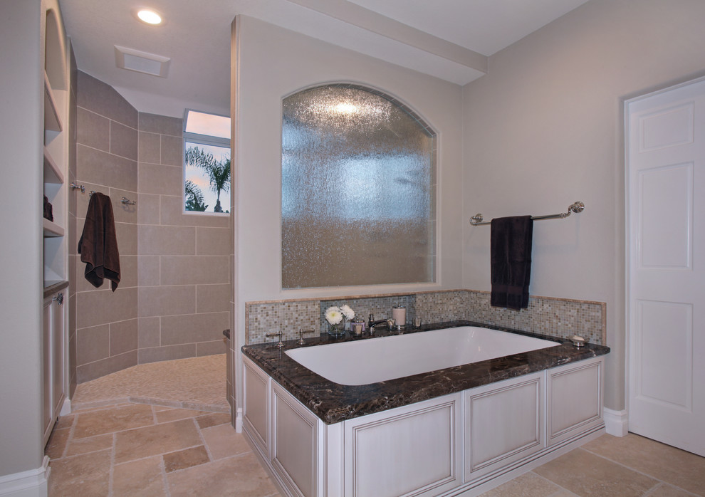 Doorless shower - huge transitional master beige tile and mosaic tile travertine floor doorless shower idea in Orange County with an undermount sink, furniture-like cabinets, white cabinets, marble countertops, an undermount tub, a two-piece toilet and beige walls