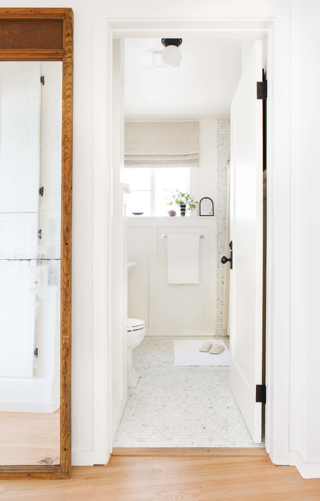 Exemple d'une salle de bain principale chic avec une douche d'angle, WC à poser, un carrelage blanc, du carrelage en marbre, un mur blanc, un sol en marbre, un lavabo de ferme, un sol blanc et une cabine de douche avec un rideau.
