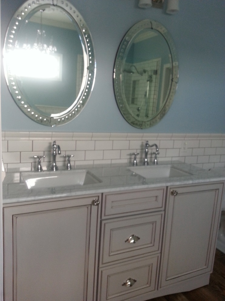 Exempel på ett mellanstort klassiskt en-suite badrum, med luckor med profilerade fronter, vita skåp, en hörndusch, vit kakel, tunnelbanekakel, blå väggar, mellanmörkt trägolv, ett undermonterad handfat, marmorbänkskiva, blått golv, dusch med gångjärnsdörr och ett badkar med tassar