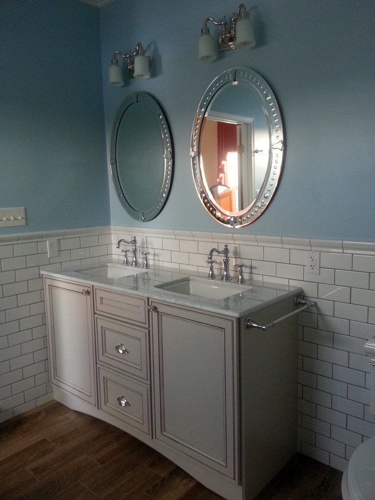 Medium sized classic ensuite bathroom in Other with beaded cabinets, white cabinets, a claw-foot bath, a corner shower, white tiles, metro tiles, blue walls, medium hardwood flooring, a submerged sink, marble worktops, blue floors and a hinged door.